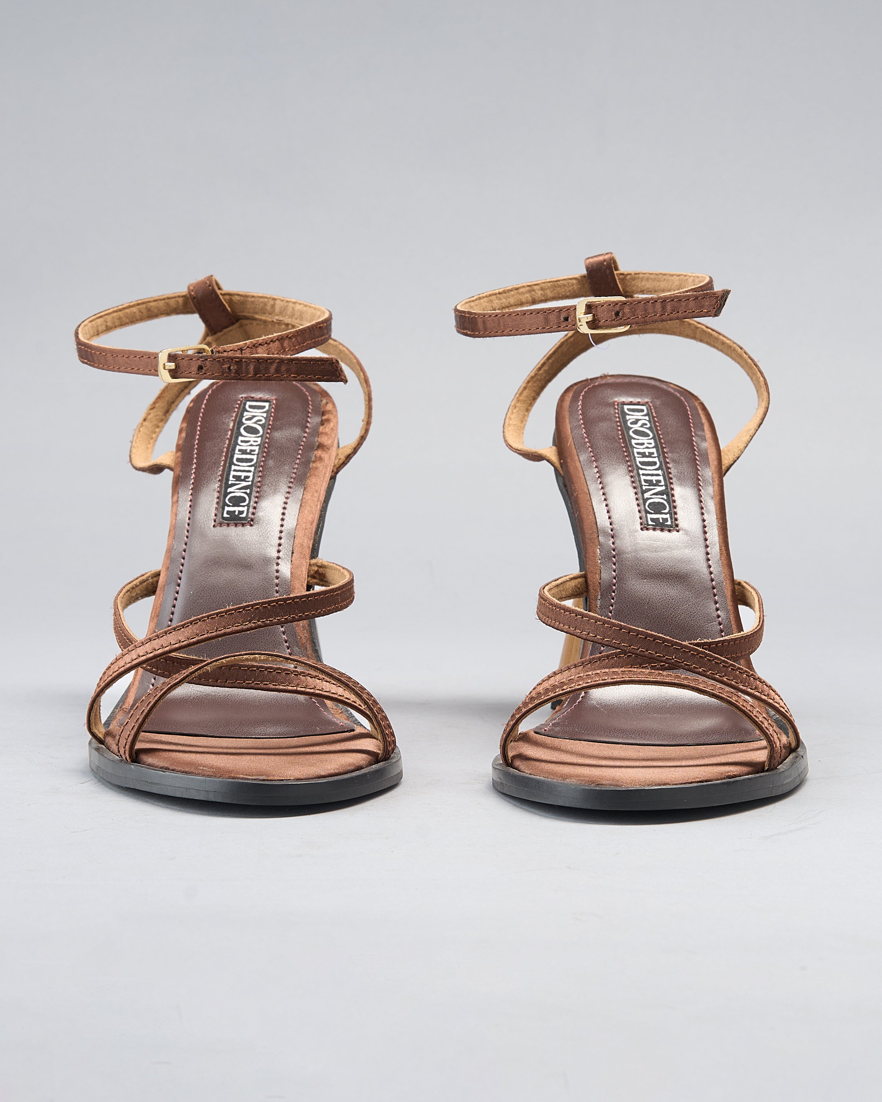 strappy sandal elevated by a hand-turned wooden heel, shaped like a goblet for balance and visual drama