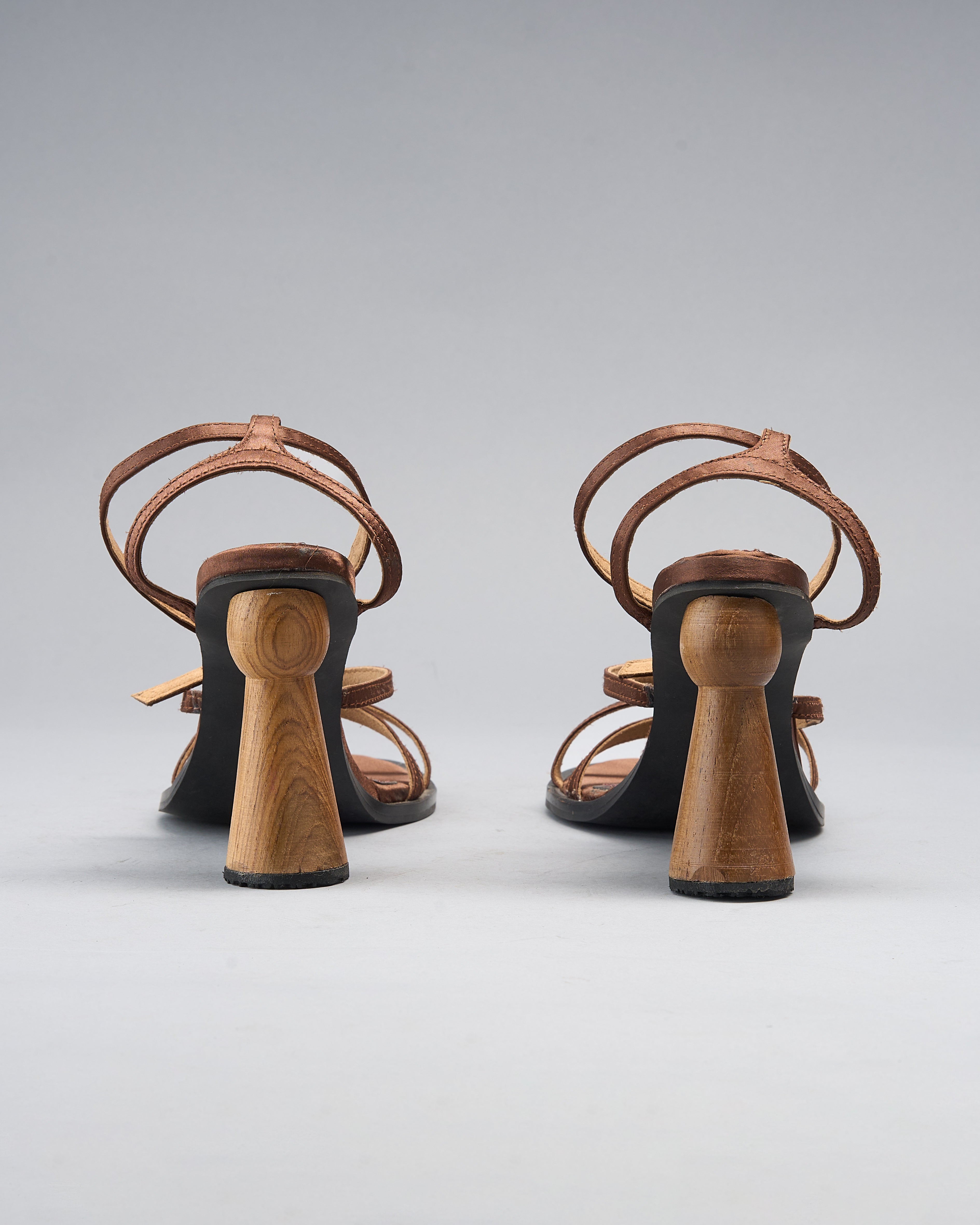 strappy sandal elevated by a hand-turned wooden heel, shaped like a goblet for balance and visual drama