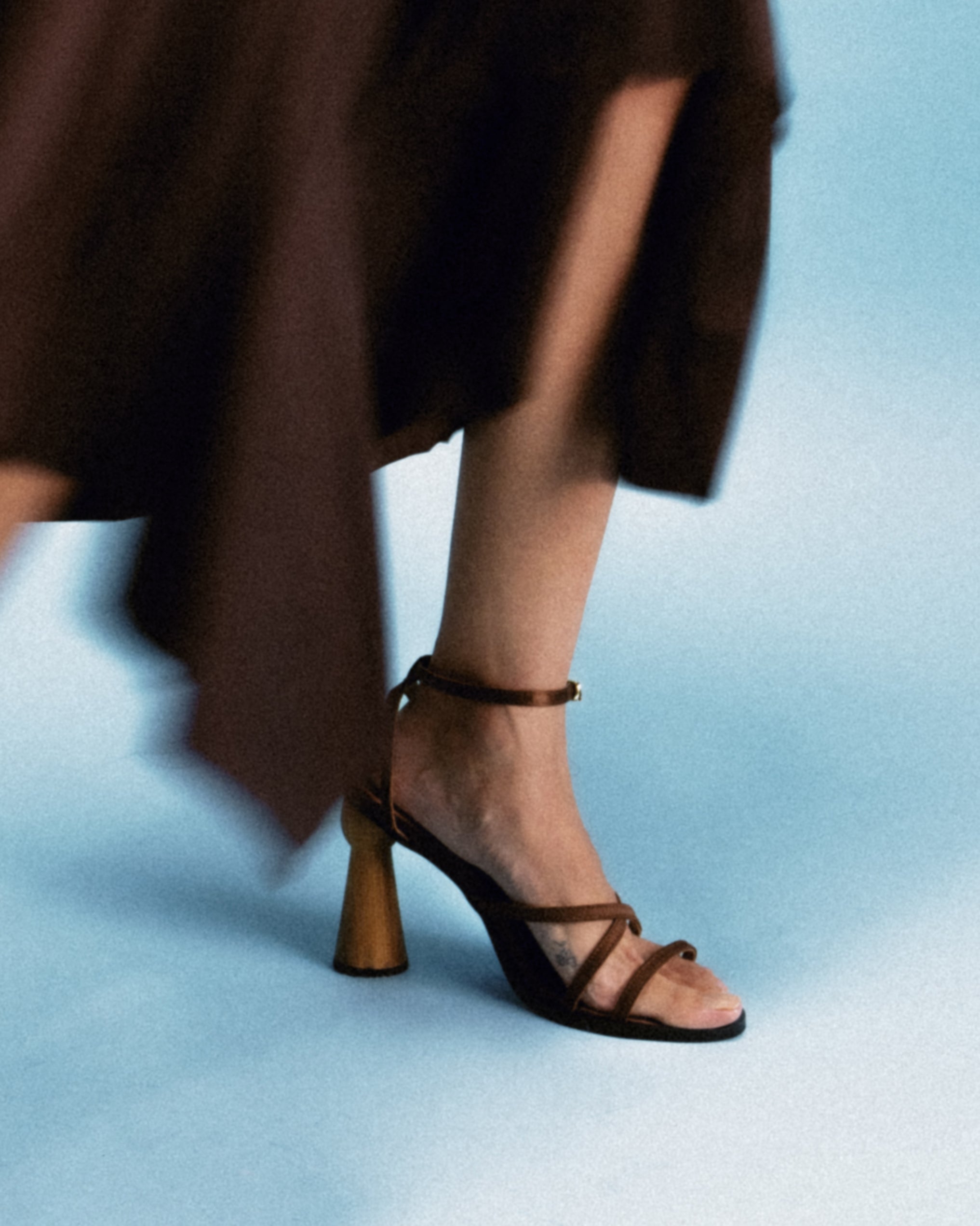 strappy sandal elevated by a hand-turned wooden heel, shaped like a goblet for balance and visual drama