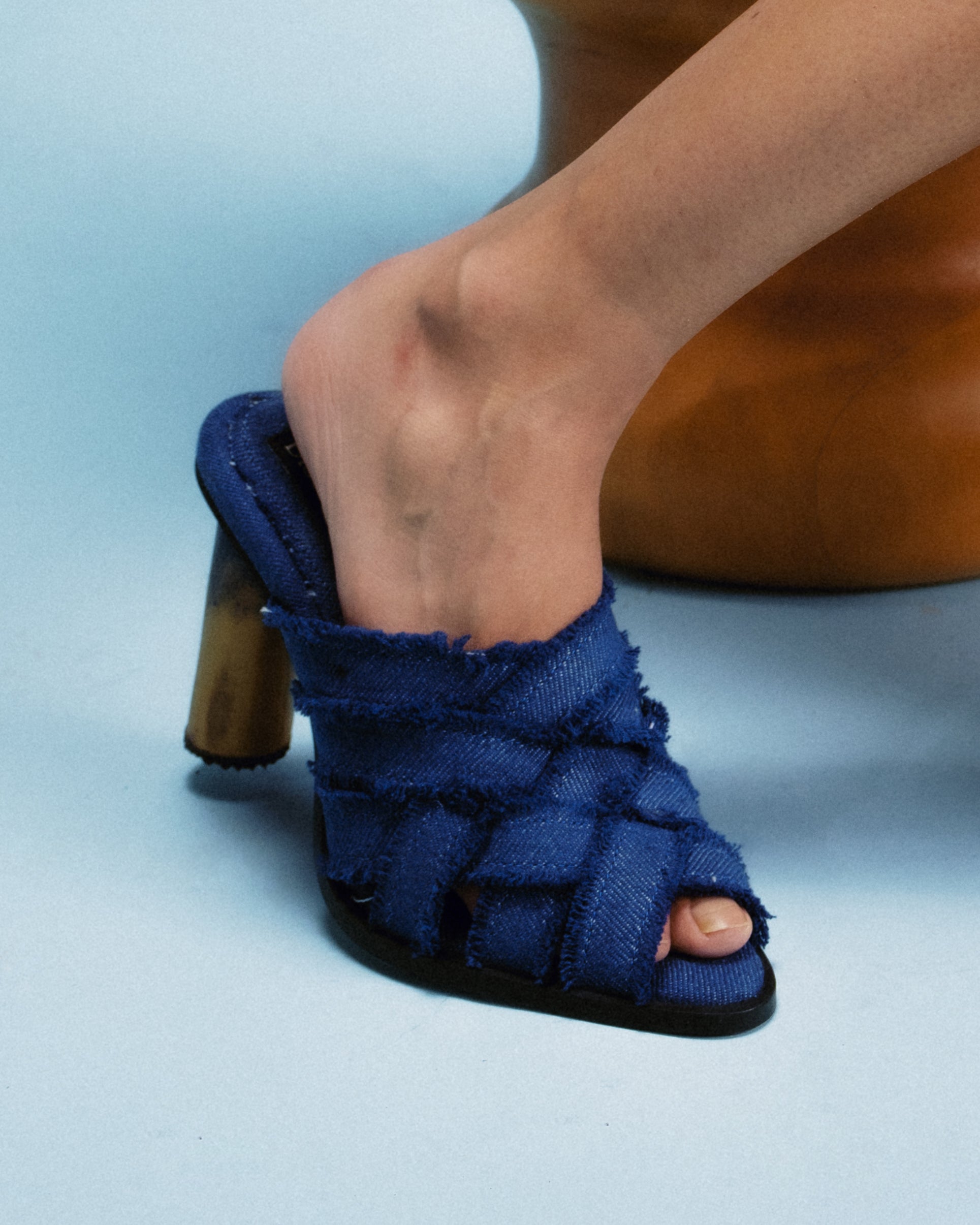 handwoven denim sandal crafted from recycled cotton, grounded by a hand-built teak wood heel